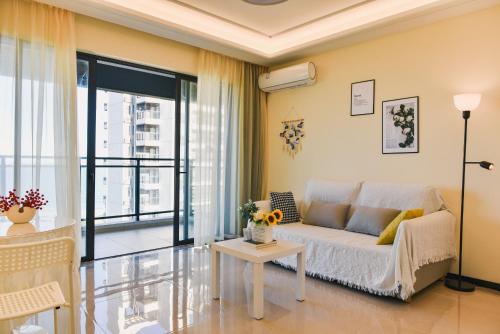 uma sala de estar com um sofá e uma mesa em Sea View Apartment with Washer Dryer Projector Refrigerator and Kitchen Shantou South High-Speed Railway St ation em Shantou