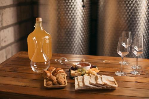 una mesa de madera con una botella de vino y copas de vino en ARMBEE Honey Farm en Alaverdi