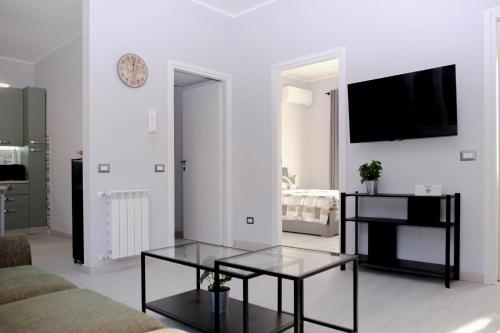 a white living room with a table and a tv at Easy Stay Rome 2 - The Easy Way in Rome