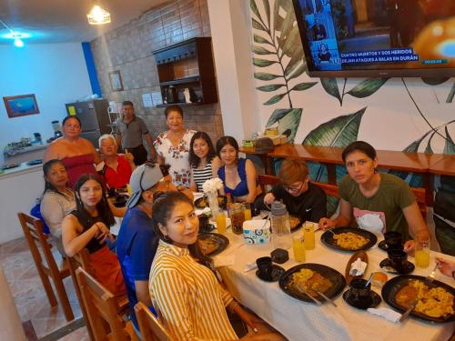 grupa ludzi siedzących przy stole jedzących jedzenie w obiekcie Descanso del Petrel w mieście Puerto Ayora