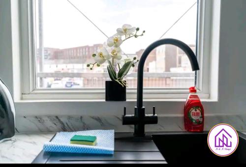 a kitchen counter with a sink and a window at Havelock Apartments, City Centre Location in Swindon