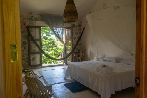 ein Schlafzimmer mit einem Bett und einem großen Fenster in der Unterkunft M a r e a V i v a in Zipolite