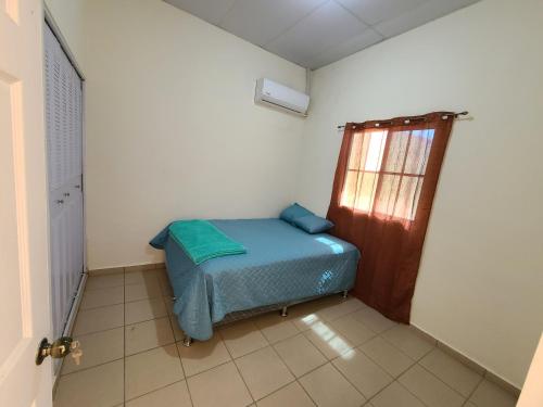 a small room with a bed and a window at Casa en Residencial Altos de Ciudad pacifica in San Miguel