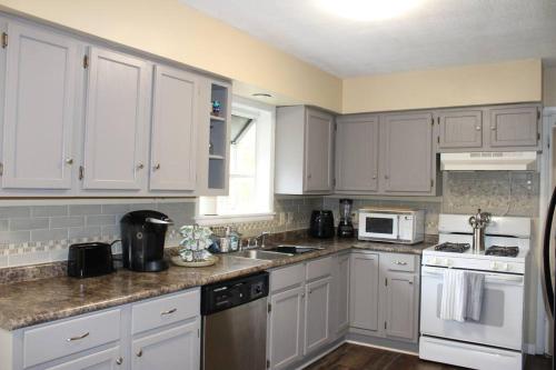 a kitchen with white cabinets and white appliances at Birchwood Place in Little Rock