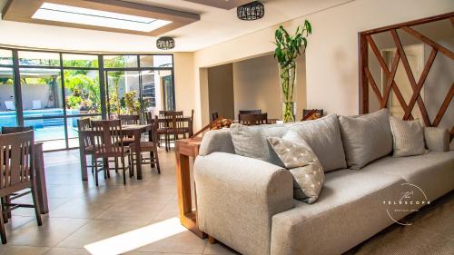 a living room with a couch and a table and chairs at The Telescope Boutique Lodge in Victoria Falls