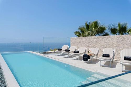 a group of lounge chairs and a swimming pool at VIPluxurySONEVA in Kendhoo