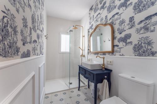 y baño con lavabo azul y espejo. en Apartamento Turístico KHöALA HOME en Merida