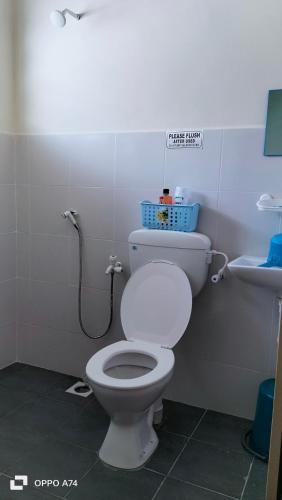 a bathroom with a white toilet and a sink at Homestay Kak Ninie in Teluk Intan