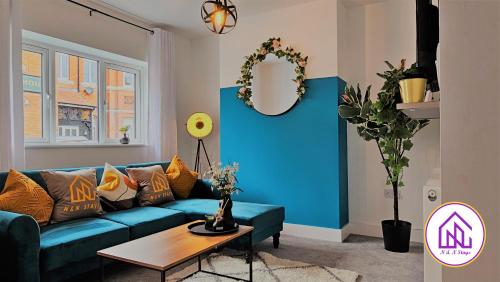 a living room with a blue couch and a table at Redcliffe House, Stylish House Close To Designer Outlet in Swindon