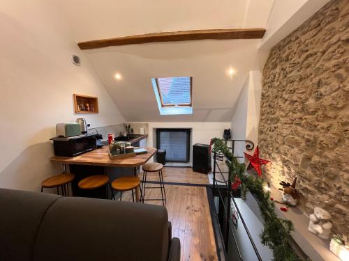 a kitchen and living room with a stone wall at Le nid d’Isa in Hautvillers