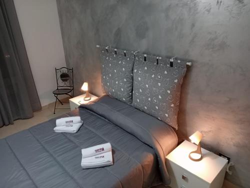a bedroom with a bed with two lamps on it at sciuliddA Casa Vacanze in Avola