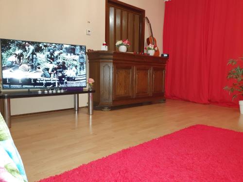 ein Wohnzimmer mit einem TV und einem roten Vorhang in der Unterkunft Perl in Amsterdam