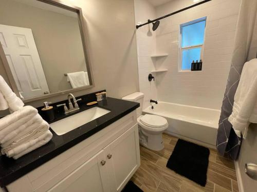 La salle de bains est pourvue d'un lavabo, de toilettes et d'un miroir. dans l'établissement New Midtown Modern Home with Backyard (Unit A), à Phoenix