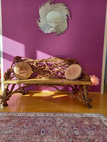 a room with a bench with a mirror on a purple wall at FLORES, Ferienhaus Zimmer, im Grünen, 5 Gehminuten ins Zentrum, Parkplatz, zero emissions in Bad Ischl