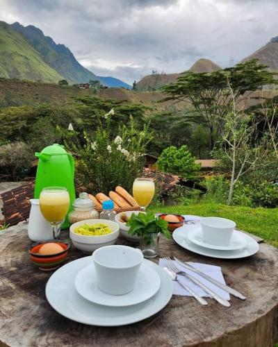 een tafel met borden eten en glazen sinaasappelsap bij Araplay Lodge in Santa Teresa