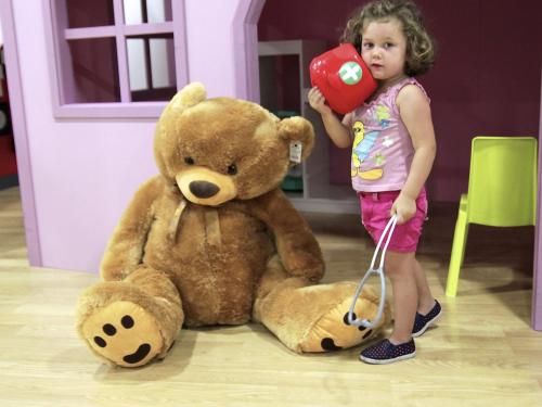 a little girl standing next to a large teddy bear at Magic Cristal Park in Benidorm