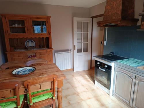 - une cuisine avec une table en bois et une cuisinière dans l'établissement F2 classé 3 étoiles vue montagne, extérieur clos, à Arles-sur-Tech