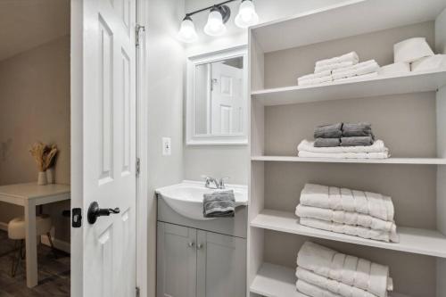 a white bathroom with a sink and towels at Stylish Rancher, Great Location! in Hanover