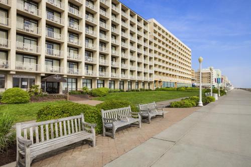 a row of benches in front of a building at Country Inn & Suites by Radisson, Virginia Beach Oceanfront , VA in Virginia Beach