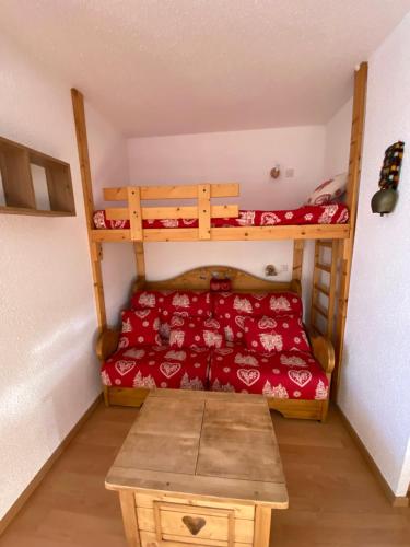 a room with two bunk beds and a table at Charmant T2 montagne ensoleillé in Val Thorens