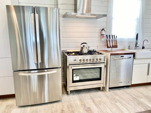 a kitchen with a stainless steel refrigerator and a stove at Eleuthera Retreat - Private Villa & Cottages on pink sand beachfront in North Palmetto Point