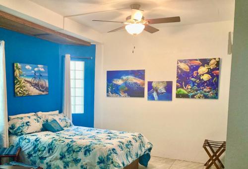 a bedroom with four paintings on the wall at JAGUAR MORNING STAR in Caye Caulker