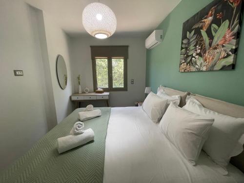 a bedroom with a large bed with towels on it at Aryiro's Residence,Cozy&Sunny in Alikianós