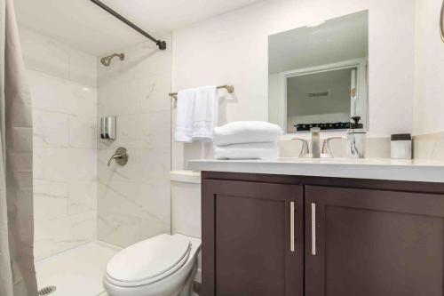 een witte badkamer met een toilet en een wastafel bij Your Downtown Cozy Studio With Backyard Unit C in Phoenix