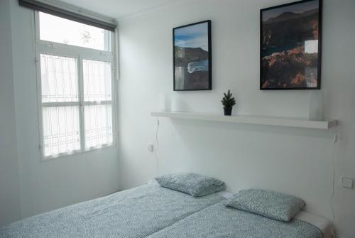 a white bedroom with a bed and two windows at VV - La Plazuela in Arrecife