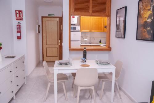 a white kitchen with a white table and chairs at VV - La Plazuela in Arrecife