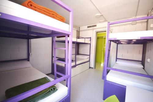 a room with purple bunk beds in a dorm room at Scout Madrid Hostel in Madrid