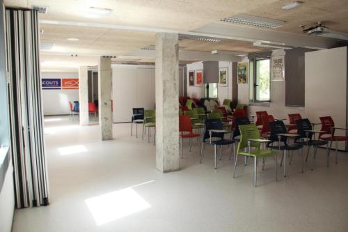 una habitación con sillas y mesas en un edificio en Scout Madrid Hostel, en Madrid