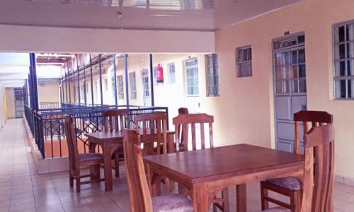 a dining room with wooden tables and chairs at Lexingtone Square in Igoji