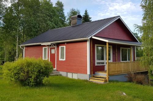czerwono-biały dom z werandą w obiekcie Hus nära sjö och säfsenresort w mieście Fredriksberg