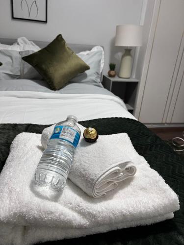 a bottle of water sitting on towels on a bed at Dalston 1 bedroom flat in London