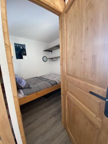 a door leading into a bedroom with a bed at Charmant T2 montagne en étage élevé. in Val Thorens