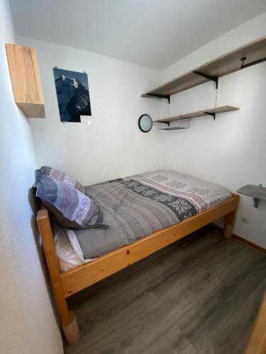 a small bedroom with a bed in a room at Charmant T2 montagne en étage élevé. in Val Thorens