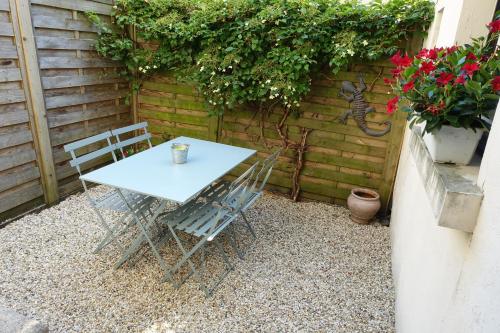 - une table et des chaises sur une terrasse fleurie dans l'établissement LA SALAMANDRE, à Bordeaux