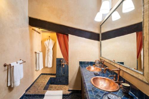 Baño con 2 lavabos y espejo en Algilà Fes Riad Medina Charme Hotel, en Fez