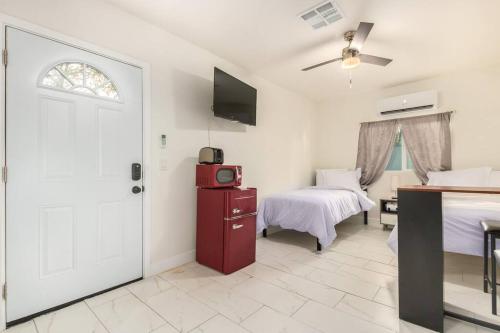 1 Schlafzimmer mit 2 Betten und einer Tür mit einem TV in der Unterkunft Your Downtown Studio With All Amenities Unit B in Phoenix