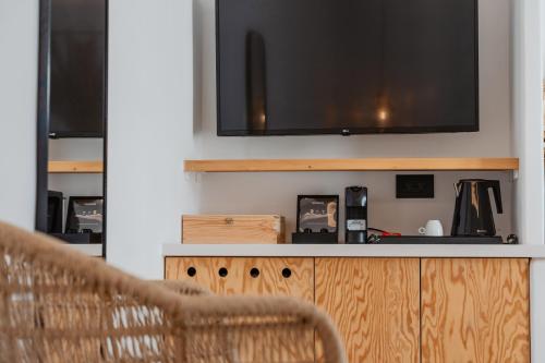 a living room with a television on a wall at Oliving Mykonos Luxury Suites in Klouvas
