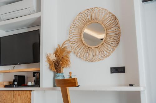 a mirror hanging on a wall in a living room at Oliving Mykonos Luxury Suites in Klouvas