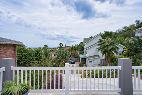 a white picket fence in front of a house at Sunset Haven Villa in Beau Vallon