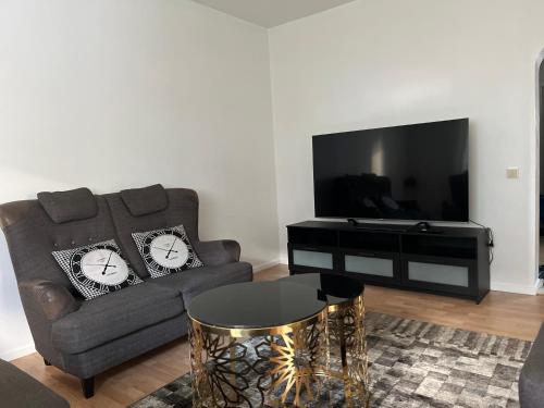 a living room with a couch and a flat screen tv at LHM in Borås