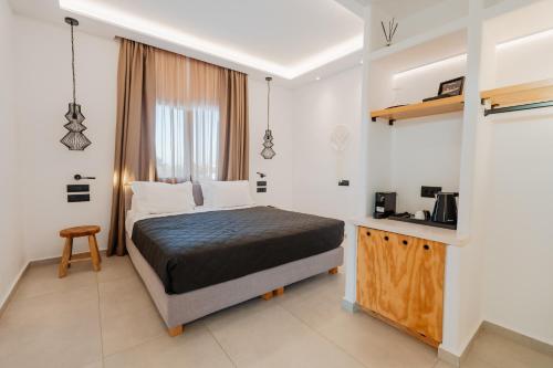 a bedroom with a bed and a table in it at Oliving Mykonos Luxury Suites in Klouvas