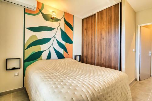 ein Schlafzimmer mit einem Bett und einer farbenfrohen Wand in der Unterkunft Logement 4 pièces Étang St Paul in Saint-Paul