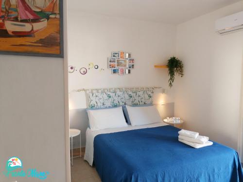 a bedroom with a bed with a blue bedspread at CASA FRONTE MARE in Santa Teresa di Riva