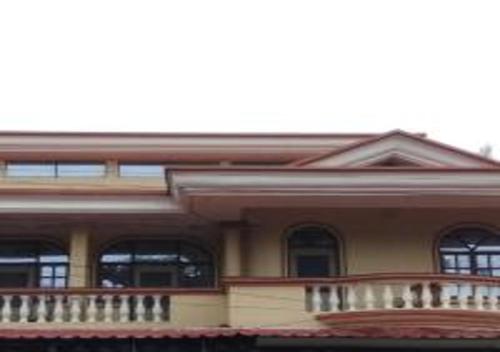 a large house with a porch and a balcony at Jas Guest House in Mobor Goa