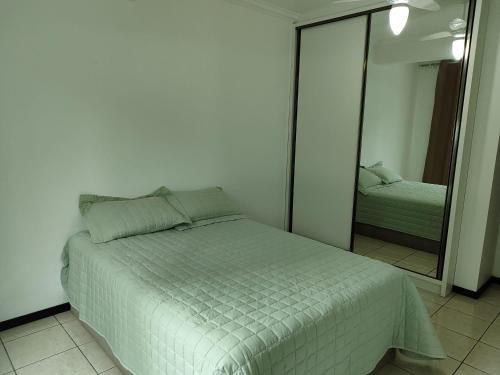 een slaapkamer met een bed en een grote spiegel bij Apartamento em Torres in Torres