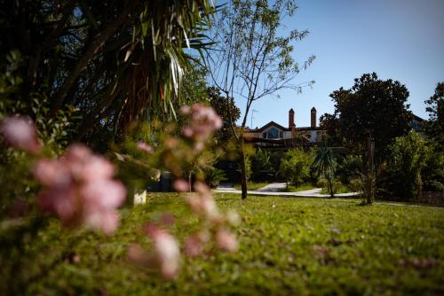 a yard with pink flowers in front of a house at Hotel Villa Rizzo Resort and Spa in San Cipriano Picentino